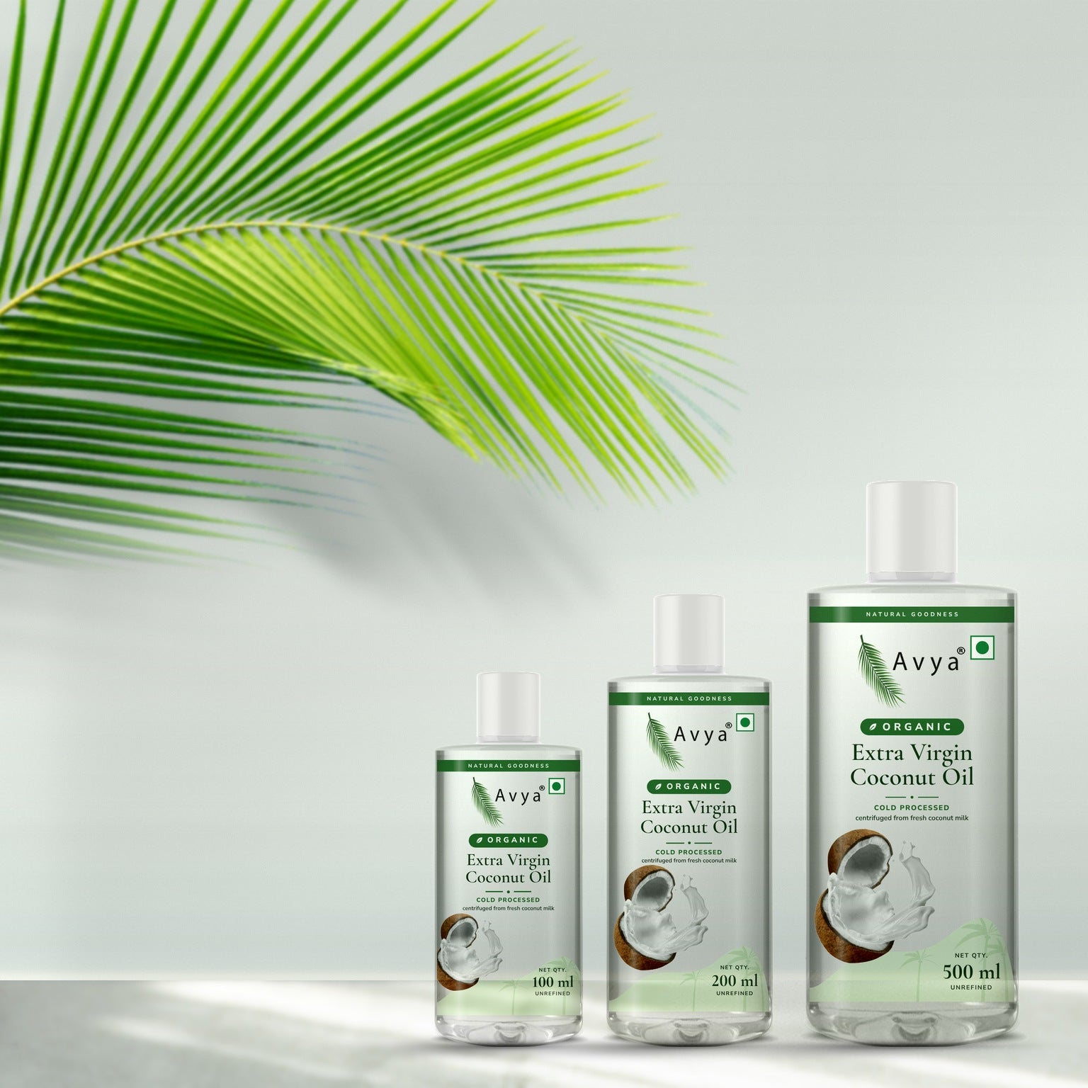 Avya Organic Extra Virgin Coconut Oil bottles with a coconut palm leaf in natural sunlight