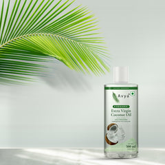 Avya Organic Extra Virgin Coconut Oil 500 ml with a coconut palm leaf in natural sunlight