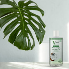 Avya Organic Extra Virgin Coconut Oil 500 ml with a monstera leaf in natural sunlight